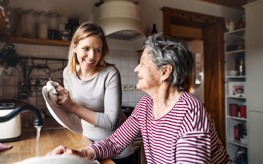 Aide à domicile avec koappy - Une jeune femme aide une senior à faire la vaisselle dans une ambiance conviviale
